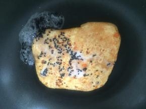 用淀粉和黑芝麻混合，将芡汁浇在饼上