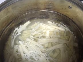 然后在锅里倒入水，煮开放入金针菇，煮3分钟
