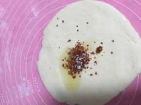 在面皮上倒上橄榄油，辣椒粉和盐