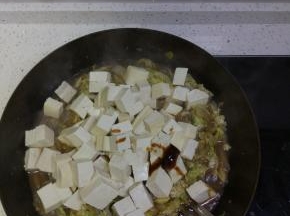 锅内白菜帮基本都软了之后加入白菜叶，加入切好的豆腐