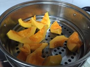 将南瓜切块，锅中加入水，南瓜块蒸煮5分钟，煮烂成泥