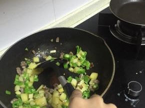 加入土豆丁，混合炒2-3分钟后加入青椒丁