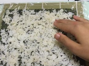 将拌好的米饭在海苔上铺均匀