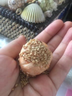 拿出熟芝麻，裹在面团上