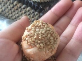 拿出熟芝麻，裹在面团上