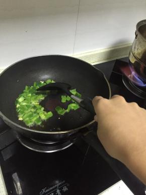 把锅预热，加入少量橄榄油，倒入青椒翻炒