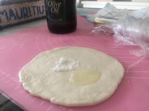 将面团擀开，加上少量盐和橄榄油，盐作为调味，橄榄油可使薄饼更加酥脆。