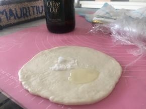 将面团擀开，加上少量盐和橄榄油，盐作为调味，橄榄油可使薄饼更加酥脆。