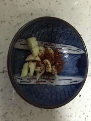 把大蒜压碎，加入干辣椒粉
