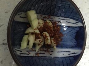把大蒜压碎，加入干辣椒粉