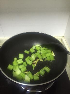 将芹菜段放入锅中，翻炒