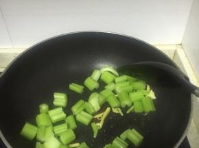 将芹菜段放入锅中，翻炒