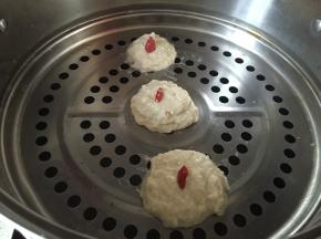将拌好的土豆面粉捏成饼状，洗干净枸杞置于顶部，底部刷橄榄油置于笼屉上，蒸8分钟左右