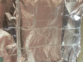 在烤盘上铺上锡纸，将饭放入锡纸中，然后包起来