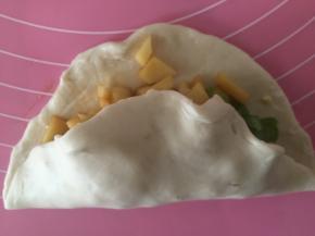 将面团擀开，加上土豆馅料和其他配菜，对折包住。在一边编麻花使得封口紧密