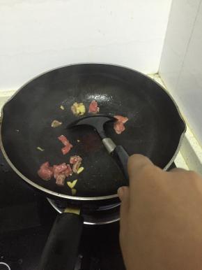 加入牛肉丁翻炒2-3分钟，至变色，加入少量盐