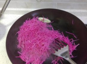 锅内放油加热放入葱蒜爆香，加入萝卜丝进行翻炒