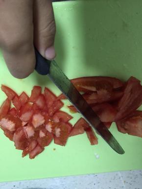 豆腐在盒内切片，倒出置于碗底，将西红柿细细切碎