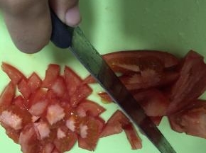豆腐在盒内切片，倒出置于碗底，将西红柿细细切碎