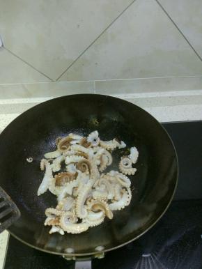 锅内放油放入葱姜蒜爆香，加入鱿鱼进行翻炒
