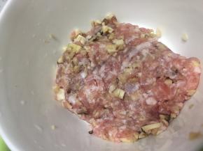 将香菇丁加入肉糜中，切匀，加入少量盐拌匀