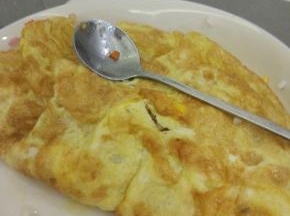 煎好的蛋饼放入盘子里，把炒好的米饭放入蛋饼