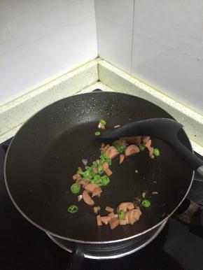 锅中加入适量的橄榄油，放入杭椒和香肠混合丁，翻炒1-2分钟