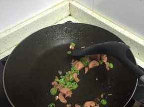 锅中加入适量的橄榄油，放入杭椒和香肠混合丁，翻炒1-2分钟