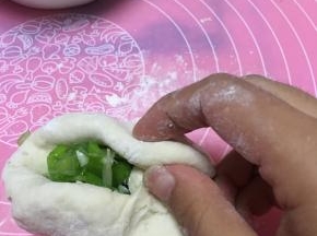 将大葱切末，将面团略微擀开，放入香葱，包好