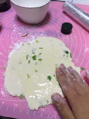 擀面，将面团擀开。加上橄榄油，少许盐，将橄榄油和盐抹匀。