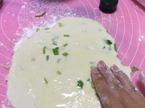 擀面，将面团擀开。加上橄榄油，少许盐，将橄榄油和盐抹匀。
