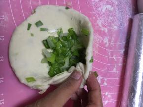 再将面团略微擀开，再次放入香葱，包好