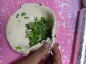 再将面团略微擀开，再次放入香葱，包好