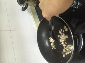 倒入香菇丁，加入少量料酒和鲜酱油翻炒至杏鲍菇变软。