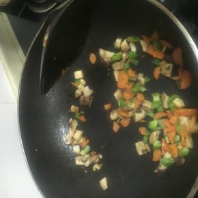 加入青椒丁，胡萝卜丁，放入少量的盐，翻炒