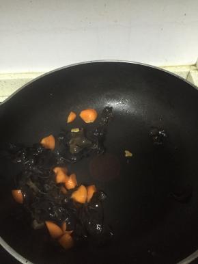 倒入胡萝卜，再倒入黑木耳，翻炒2-3分钟，至变软
