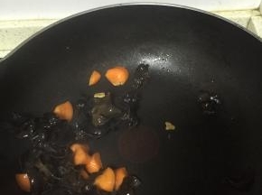 倒入胡萝卜，再倒入黑木耳，翻炒2-3分钟，至变软