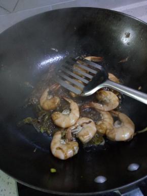 锅内放油放入葱姜蒜爆香，加入虾进行翻炒如图