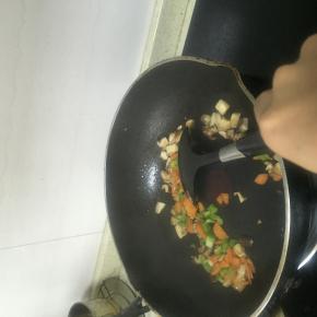 加入青椒丁，胡萝卜丁，放入少量的盐，翻炒