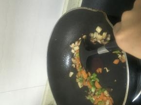加入青椒丁，胡萝卜丁，放入少量的盐，翻炒