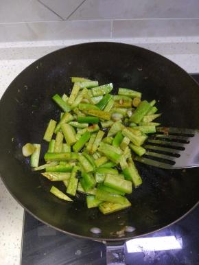 锅内放入切好的萝卜条进行翻炒，待萝卜条颜色微黄之后加入适量的热水