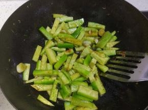 锅内放入切好的萝卜条进行翻炒，待萝卜条颜色微黄之后加入适量的热水