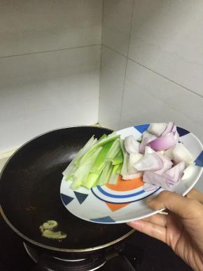 然后倒入大葱、洋葱片，炒3分钟，至洋葱变软