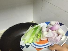 然后倒入大葱、洋葱片，炒3分钟，至洋葱变软