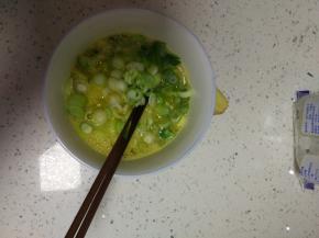 切碎的小葱加入蛋液中，放入适量的盐调味
