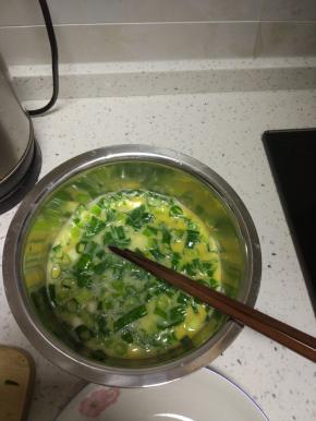 切好的葱段加入蛋液中，加入适量的盐,一点醋,打散