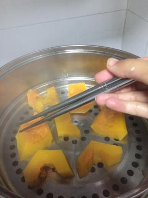 将南瓜切块，锅中加入水，南瓜块蒸煮5分钟，煮烂成泥