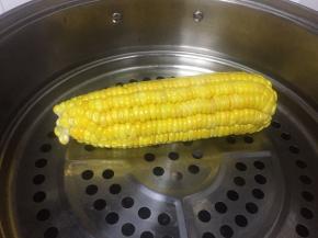 取一个玉米，洗干净，去皮，放在笼屉上蒸熟