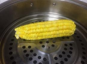 取一个玉米，洗干净，去皮，放在笼屉上蒸熟