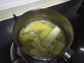 两天后，拿出腌制好的柚子皮，在锅里加入水，大火煮沸，和冰糖一起放入水中熬制